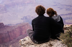 絶景スポットで寄り添って座るカップル