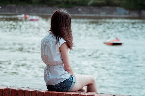 湖のほとりに座る女の子