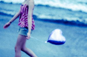 波打ち際を歩く風船を持った女の子