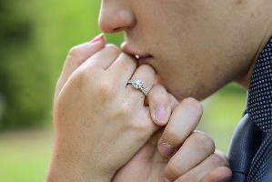 指輪をした手にキスする男性