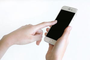 白いiPhoneとそれに触れる指