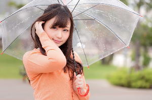 傘を差しながら髪をかき上げる女性